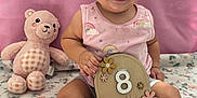 Aileen is registered to the contest to win money with this photo: baby, bed, bodypart, couch, cushion, face, finger, furniture, happy, head, homedecor, indoors, person, photography, plush, portrait, sitting, smile, teddybear, toy