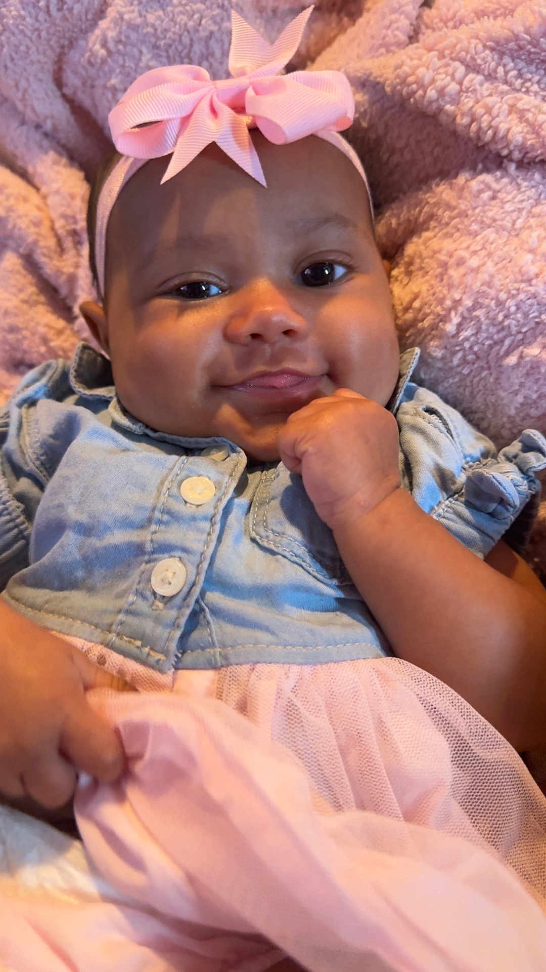 De'Lysia is registered to the contest to win money with this photo: baby, child, infant, smiling, headband, bow, denim_jacket, pink, tulle_skirt, blanket, soft_texture, cute, portrait, hand, face, indoors, cozy, happy, clothing, young