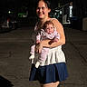 Leann Marie joined the competition — help win amazing prizes! asphalt, baby, building, car, child, clothing, curious, dark, face, footwear, holding, light, night, outdoor, pajamas, person, shadow, smiling, street, woman