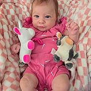 Leann Marie joined the competition — help win amazing prizes! baby, blanket, checkered, child, colorful, comfort, cow_toy, cute, face, hand, indoors, infant, legs, pink_outfit, plush_toy, portrait, resting, smiling, soft_texture, unicorn