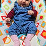 baby, infant, smiling, baby_bouncer, colorful_pattern, denim_overall, pink_socks, hands, face, eyes, happy, sitting, indoor, wood_floor, bottle, clothing, portrait, adorable, newborn, seat_pad