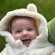 Catalina joined the competition — help win amazing prizes! baby, child, smile, hoodie, white, fluffy, pom_pom, cute, portrait, outdoor, green_background, face, happy, warm_clothing, infant, person, close_up, eyes, skin, zipper