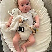 Matéo participe au concours pour gagner de l'argent avec cette photo : baby, infant, baby_lounger, blanket, teddy_bear, pacifier, pacifier_clip, person, couch, cushion, clothing, onesie, hand, foot, face, expression, indoors, newborn, comfort, cute