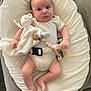 baby, baby_lounger, blanket, clothing, comfort, couch, cushion, cute, expression, face, foot, hand, indoors, infant, newborn, onesie, pacifier, pacifier_clip, person, teddy_bear