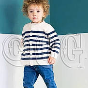 Jayden a rejoint le concours — aidez-le/la à gagner de superbes lots ! toddler, child, curly_hair, striped_sweater, jeans, barefoot, green_cushion, indoor, standing, curious, light_skin, blue_wall, white_wall, casual_clothing, portrait, young_child, cute, home, cushion, fashion
