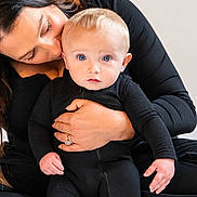 Carmine joined the competition — help win amazing prizes! adorable, baby, bedroom, black_clothing, blond_hair, blue_eyes, child, close_up, cuddling, family, indoor, infant, kiss, mother, parent, photography, portrait, sitting, smiling, white_bedding