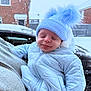 baby, blue_hat, blue_jacket, car, child, closed_eyes, cold_weather, cute, face, holding, house, outdoor, person, pom_pom, portrait, smiling, snow, tongue_out, warm_clothing, winter_clothing