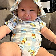 Aciel is registered to the contest to win money with this photo: arms, baby, child, clothing, couch, cute, face, happy, hat, indoors, infant, legs, onesie, person, plush, portrait, seated, smile, soft_furniture, winnie_the_pooh