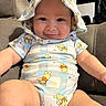 arms, baby, child, clothing, couch, cute, face, happy, hat, indoors, infant, legs, onesie, person, plush, portrait, seated, smile, soft_furniture, winnie_the_pooh