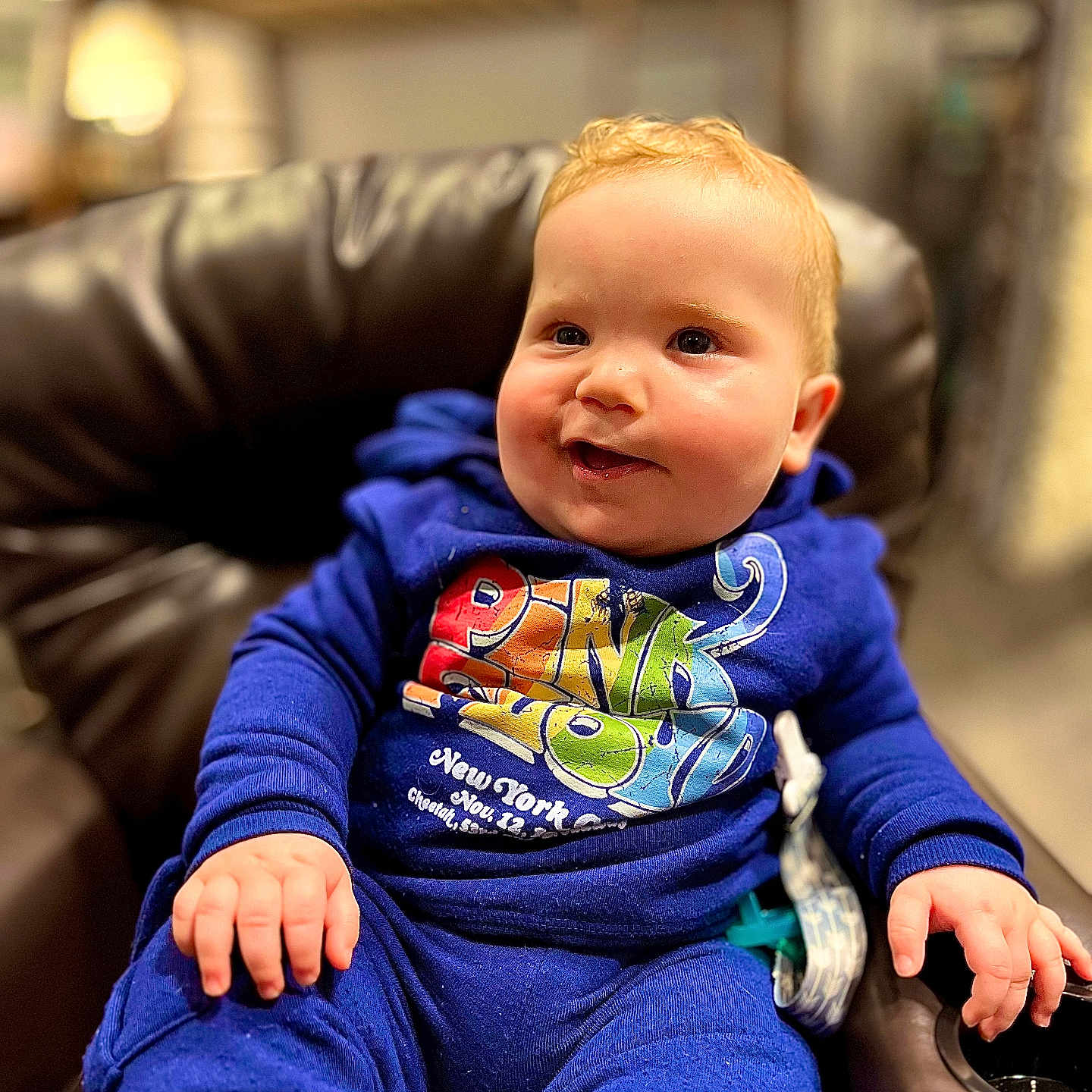 Beckham is registered to the contest to win money with this photo: armchair, baby, bodypart, chair, clothing, couch, cushion, face, finger, furniture, hand, head, jeans, knitwear, pants, person, photography, portrait, sitting, sweater