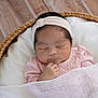 baby, basket, bed, blanket, bonnet, clothing, cradle, crib, face, furniture, hardwood, hat, head, infantbed, newborn, person, sleeping, towel, wood