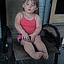 Leila is registered to the contest to win money with this photo: toddler, child, pink_top, shorts, chair, outdoor, porch, stone_floor, wooden_door, sitting, barefoot, face, hands, legs, expression, object, mesh_chair, casual, daylight, person