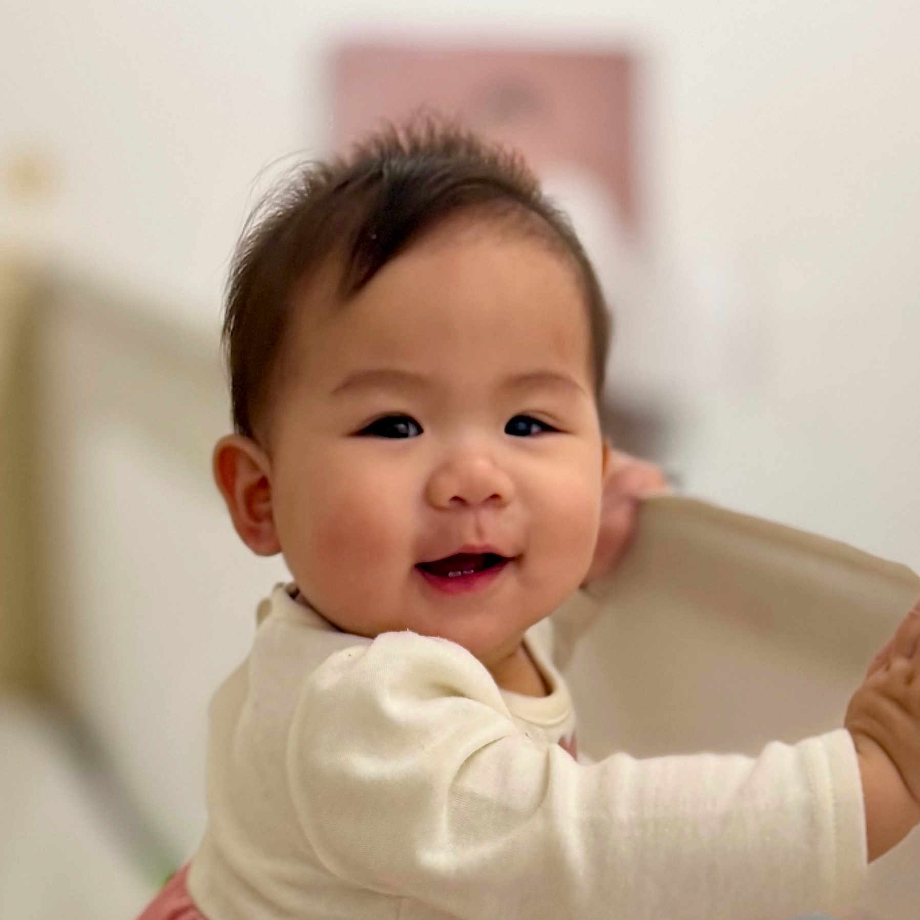 Ellie joined the competition — help win amazing prizes! baby, smiling, child, infant, face, hand, clothing, long_sleeve, fabric, indoor, portrait, cute, happy, young, skin, cheek, hair, person, holding, soft