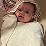 baby, child, towel, hooded_towel, blanket, face, eyes, expression, indoor, soft_texture, pacifier, knitted, cloth, cute, wrapped, laying_down, person, infant, head, ears