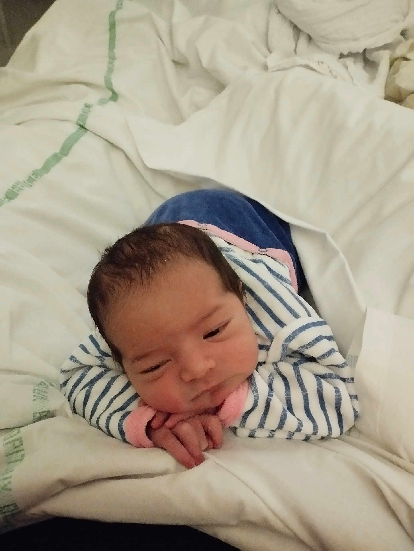 Allya a rejoint le concours — aidez-le/la à gagner de superbes lots ! baby, infant, bed, blanket, clothing, striped_onesie, hands, face, head, sleepwear, person, portrait, resting, soft, cozy, newborn, indoors, cute, child, sleep