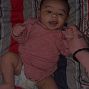 Josiah joined the competition — help win amazing prizes! baby, infant, smiling, onesie, diaper, bedding, striped_pattern, bed, hand, tattoo, holding_hands, happy, portrait, indoor, blanket, close_up, fabric, cute, newborn, person