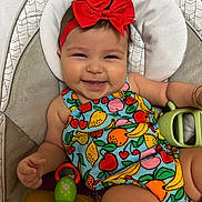Evalina joined the competition — help win amazing prizes! baby, child, smiling, headband, red_bow, fruit_pattern, colorful_clothing, toy, insect_toy, seat, cushion, happy, infant, cute, portrait, indoors, playful, holding, skin, arm
