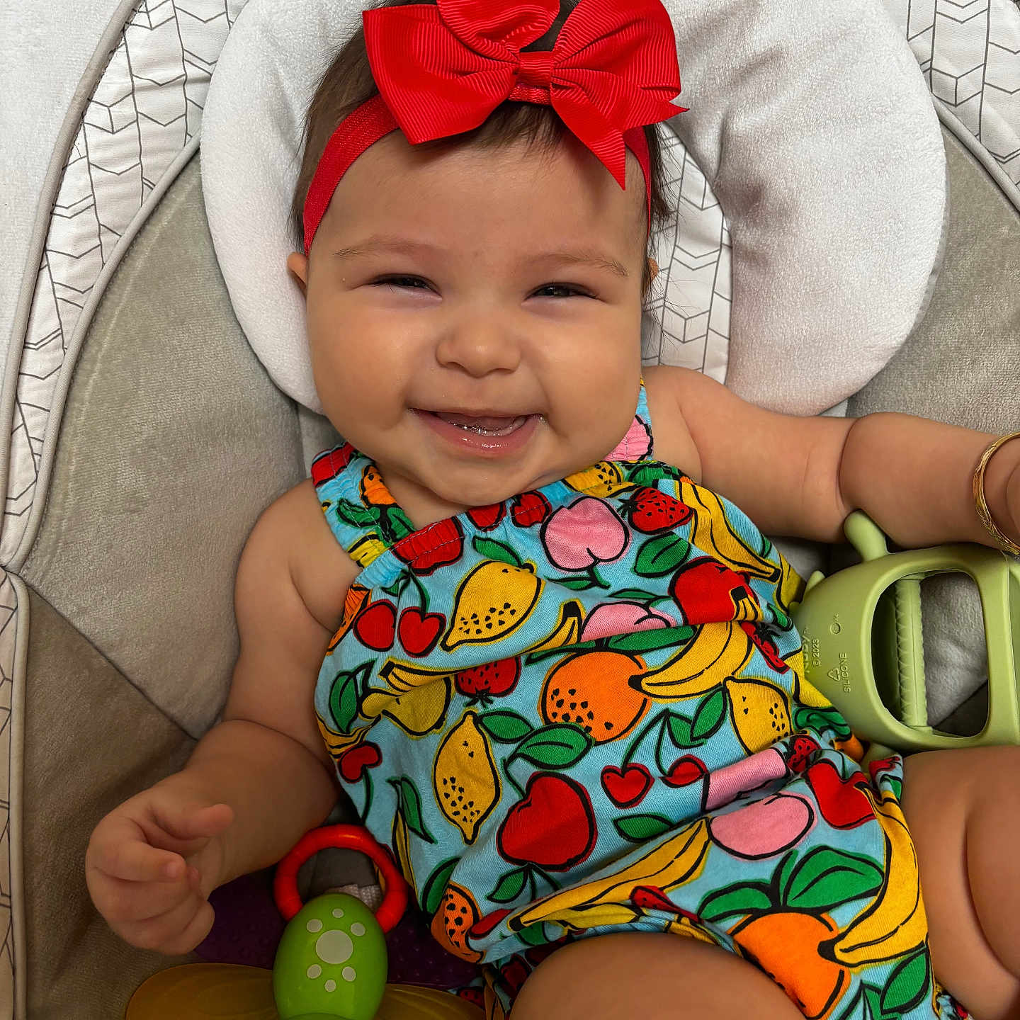 Evalina joined the competition — help win amazing prizes! arm, baby, child, colorful_clothing, cushion, cute, fruit_pattern, happy, headband, holding, indoors, infant, insect_toy, playful, portrait, red_bow, seat, skin, smiling, toy