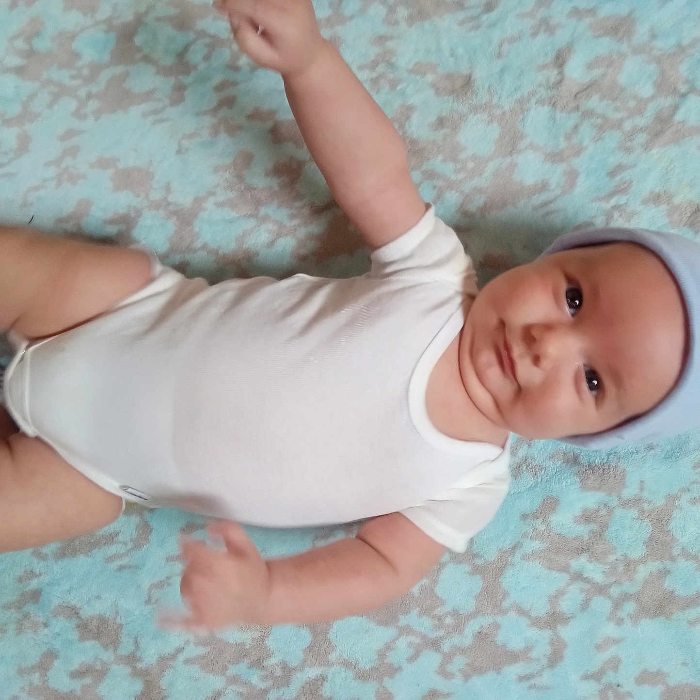 Caspian joined the competition — help win amazing prizes! arms, baby, blanket, child, chubby, curious, cute, expression, face, hat, indoors, infant, legs, lying_down, motion_blur, onesie, pattern, portrait, skin, soft_texture