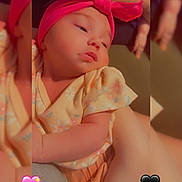 Luna is registered to the contest to win money with this photo: baby, headband, pink, yellow_outfit, floral_pattern, infant, sleepy, closeup, hand, arm, skin, cute, heart_emoji, blurred_background, portrait, indoors, soft_lighting, child, candid, love