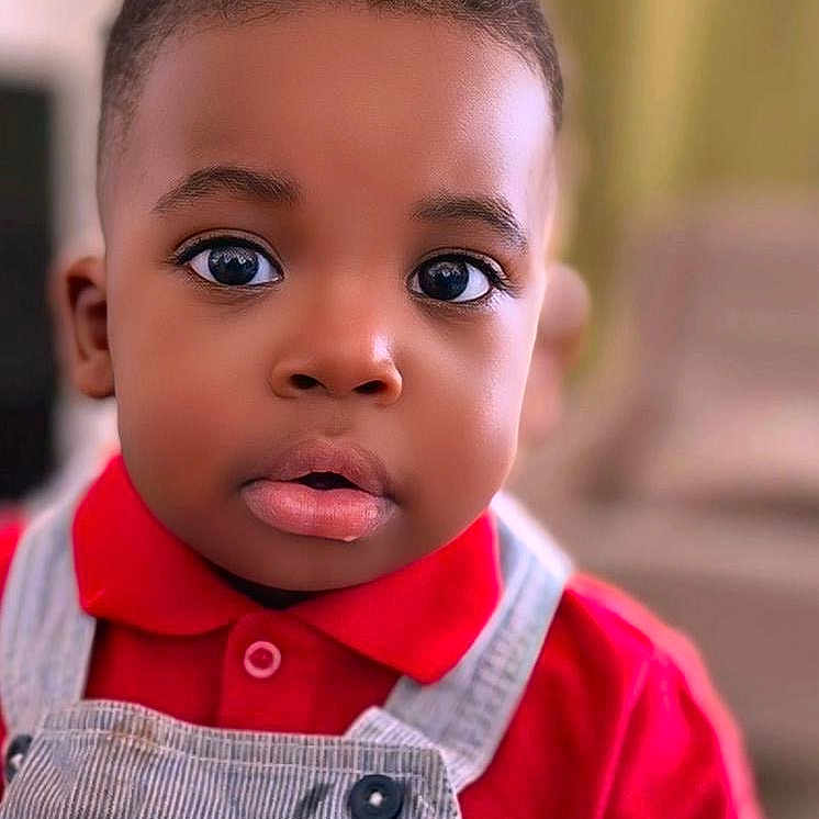 Louis a rejoint le concours — aidez-le/la à gagner de superbes lots ! baby, background_blur, child, closeup, clothing, curly_hair, cute, expression, eyes, face, fashion, head, indoors, overalls, person, portrait, red_shirt, skin, toddler, young_child