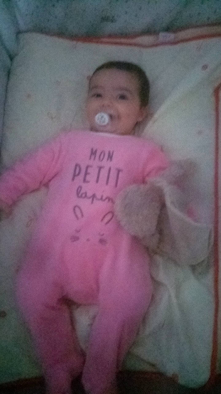 Ohana participe au concours pour gagner de l'argent avec cette photo : arm, baby, baby_toddler_clothing, cheek, comfort, dress, eye, eyebrow, face, head, headgear, human_body, infant_bed, lip, nose, person, pink, sleeve, smile, textile