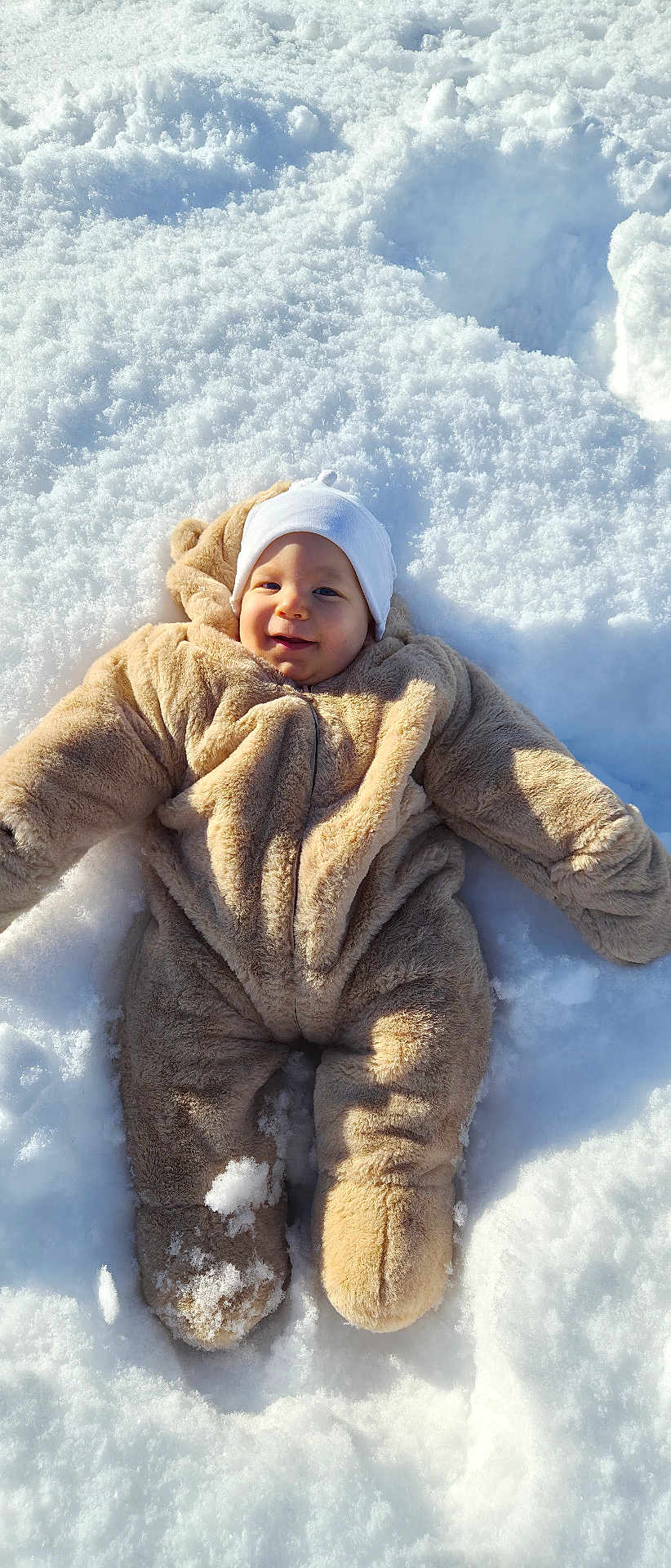 Tiago participe au concours pour gagner de l'argent avec cette photo : baby, infant, child, snow, winter, snowsuit, hat, smile, outdoors, cold, cozy, cute, cheeks, lying_down, playful, sunlight, texture, footprint, plush, portrait