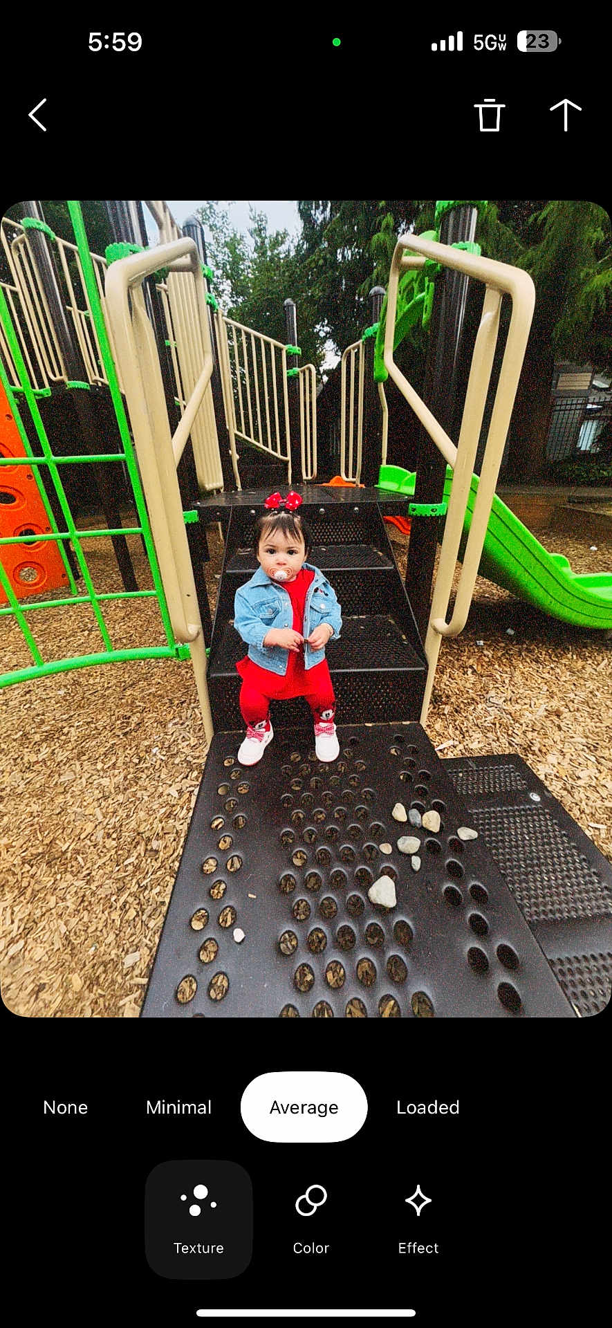 Lia Isabella is registered to the contest to win money with this photo: toddler, child, playground, playground_equipment, slide, steps, woodchips, pacifier, denim_jacket, red_clothing, bow, outdoor, person, green, orange, black, curious, sitting, baby_shoes, daylight