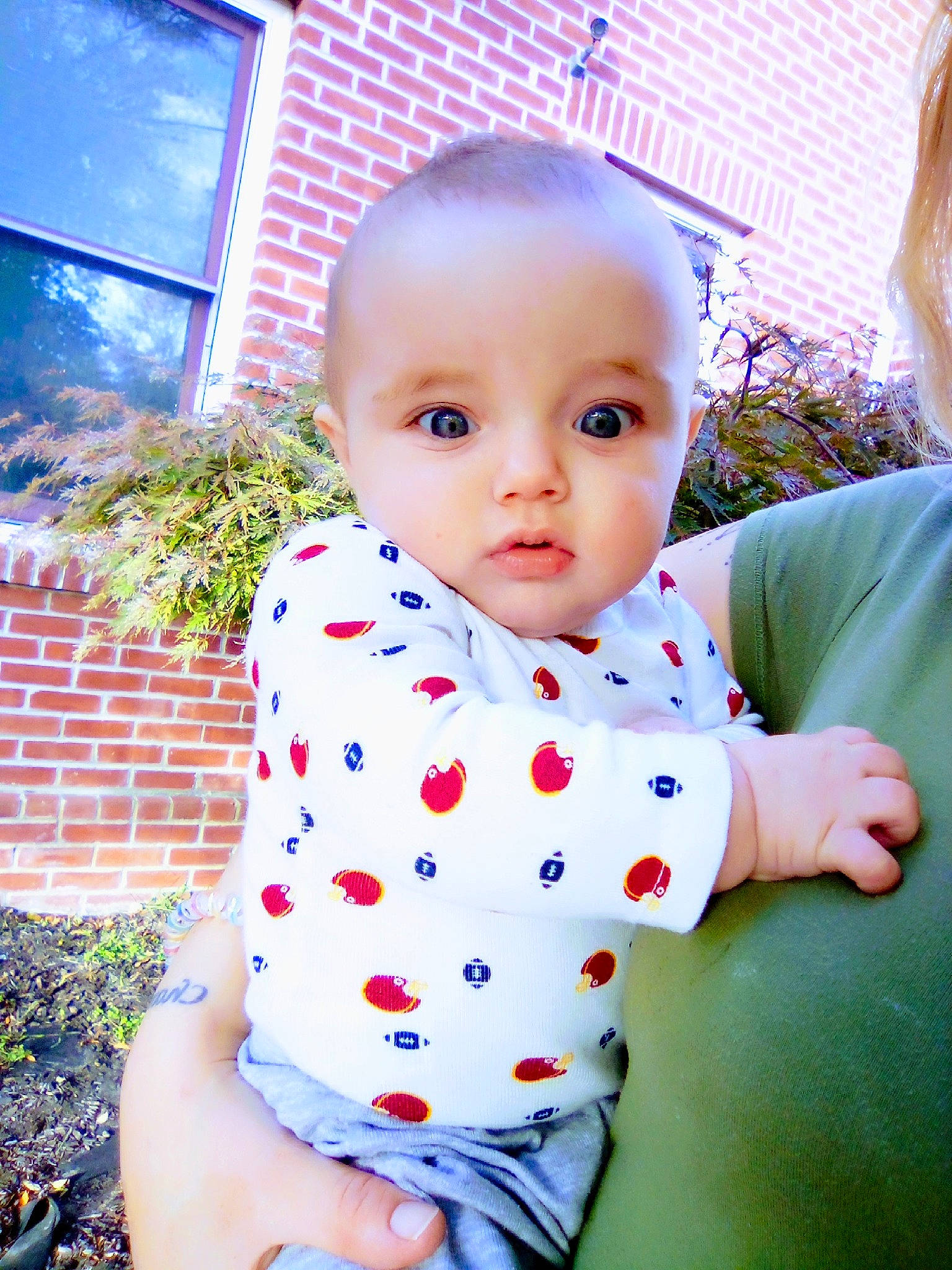 Carter is registered to the contest to win money with this photo: baby, baby_products, baby_toddler_clothing, child, collar, fun, grass, happy, pattern, person, plant, polka_dot, portrait_photography, sitting, sleeve, t_shirt, toddler, window
