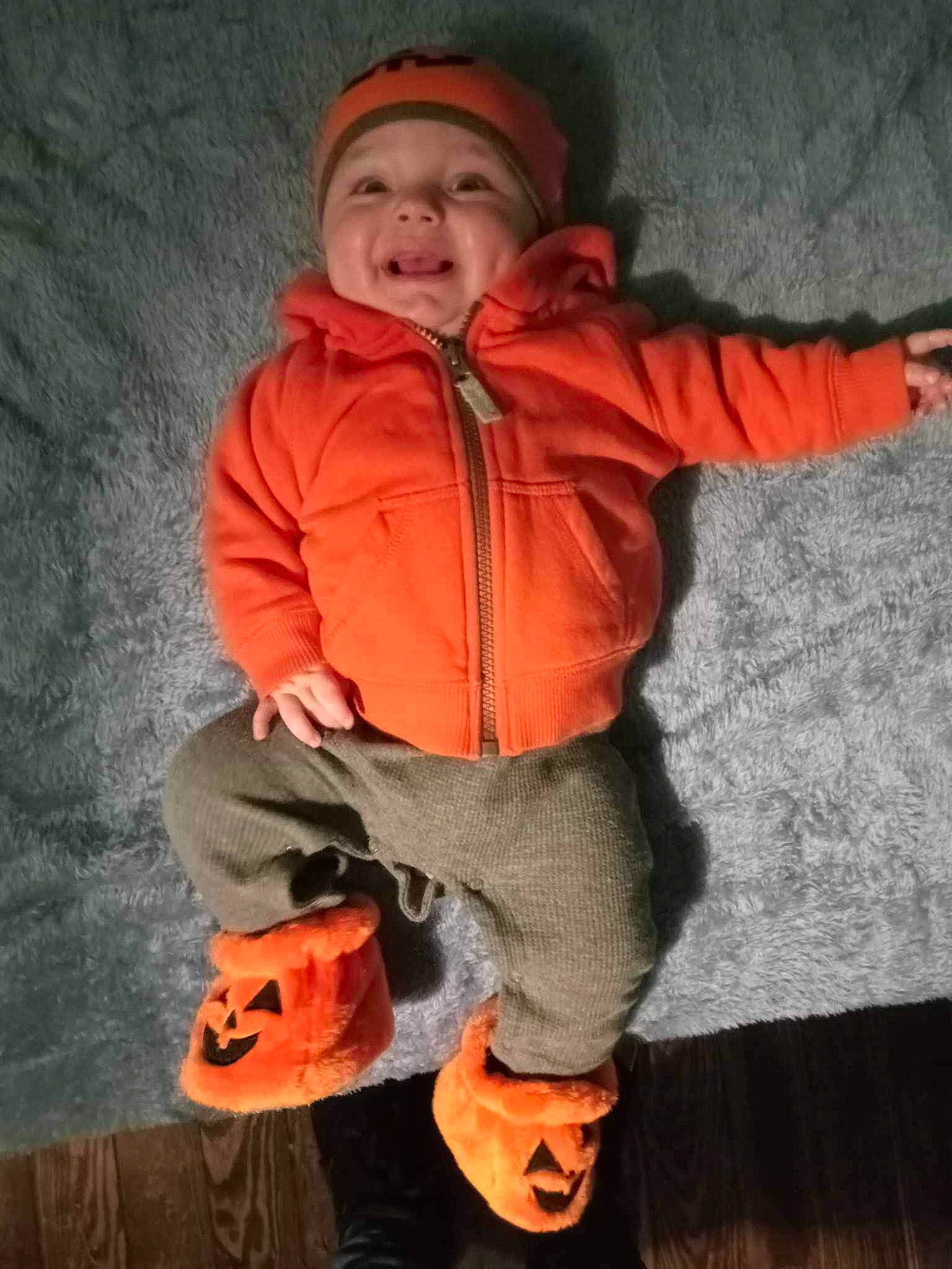 Carter is registered to the contest to win money with this photo: baby, baby_toddler_clothing, calabaza, carmine, child, fun, happy, headwear, hood, hoodie, orange, person, personal_protective_equipment, pumpkin, sitting, sleeve, smile, toddler, toy, trick_or_treat