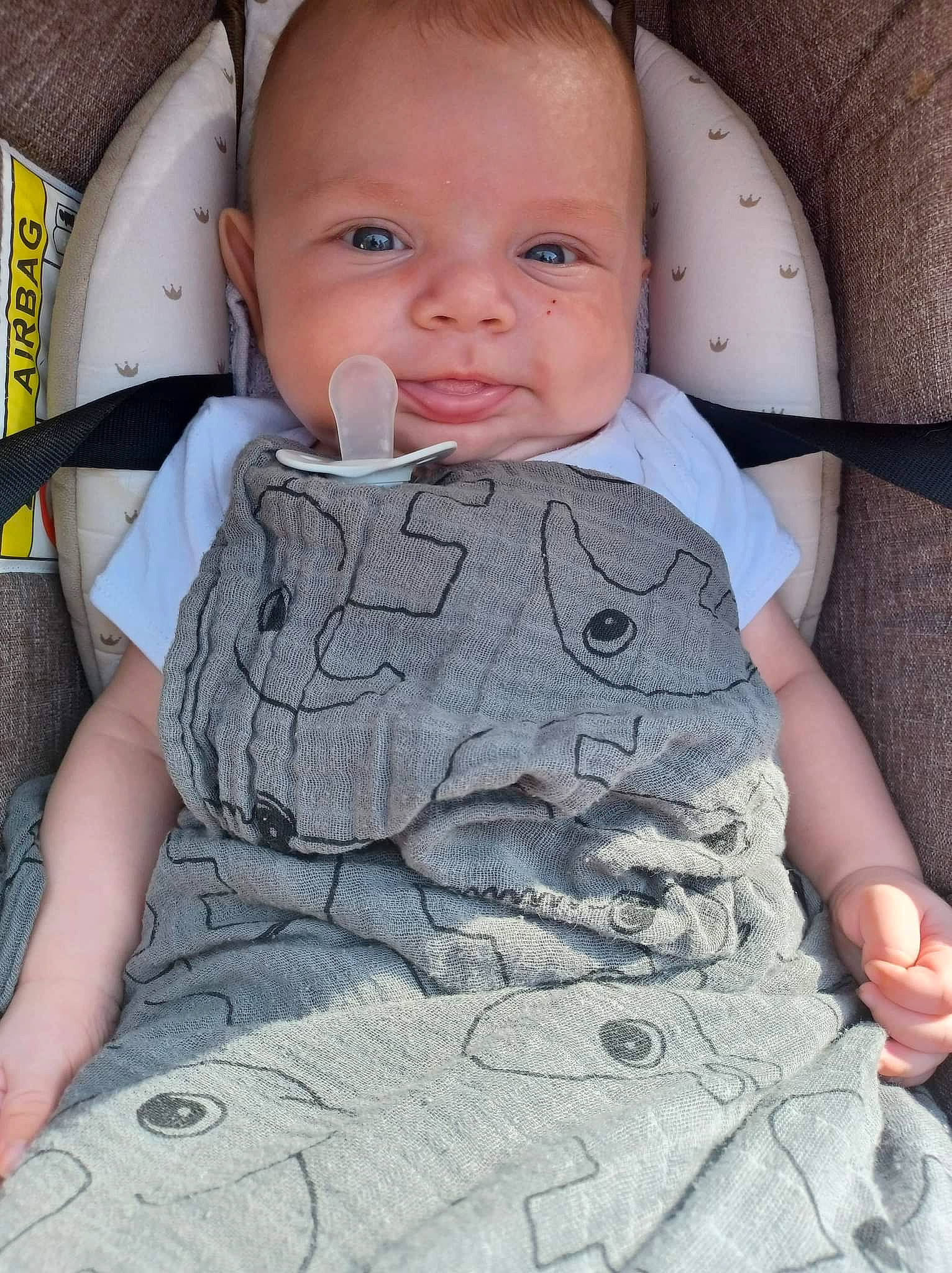 Aaron a rejoint le concours — aidez-le/la à gagner de superbes lots ! baby, baby_products, baby_safety, baby_toddler_clothing, cheek, child, comfort, face, happy, linens, nose, pattern, person, product, sitting, skin, sleeve, smile, t_shirt, textile