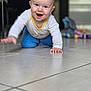 baby, child, crawling, smiling, happy, floor, tile, indoor, toy, furniture, person, clothing, long_sleeve, pants, home, cute, young, face, hands, playful