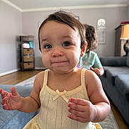 Sofia joined the competition — help win amazing prizes! toddler, child, baby, indoor, living_room, dress, couch, furniture, curly_hair, person, portrait, cute, expression, blurry_background, soft_light, floor, carpet, lamp, cabinet, home