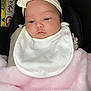 Maeve joined the competition — help win amazing prizes! baby, infant, headband, white_bib, pink_blanket, car_seat, airbag_warning, face, child, newborn, portrait, soft_texture, clothing, resting, indoor, seatbelt, cute, calm, young, wearing