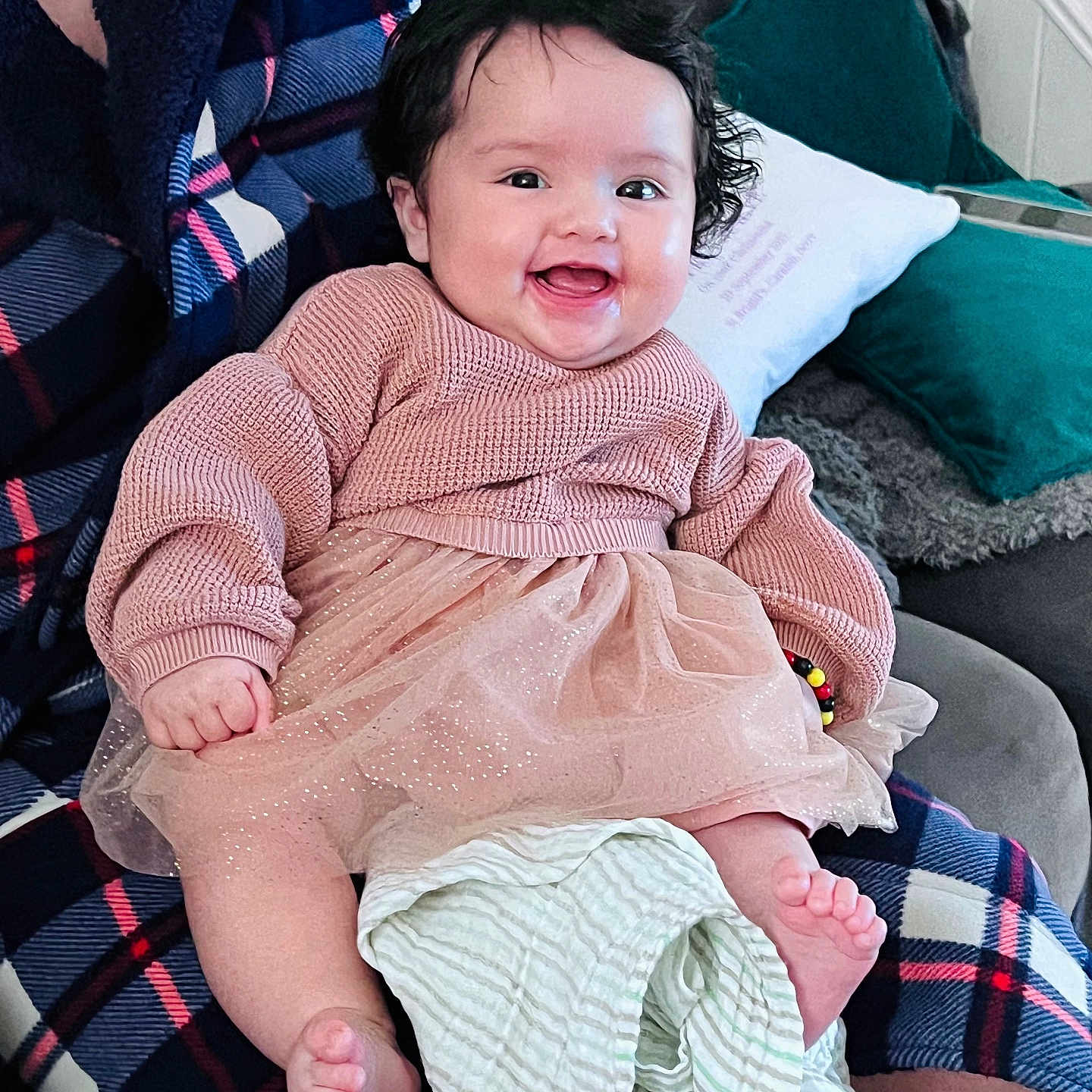 Maeve is registered to the contest to win money with this photo: baby, blanket, child, clothing, couch, cozy, cute, fabric, face, foot, hair, hand, happy, indoors, infant, person, pillow, sitting, smile, textile