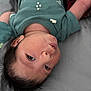Josiah joined the competition — help win amazing prizes! baby, infant, face, person, clothing, green_onesie, lying_down, portrait, curious, pout, hair, skin, head, indoors, soft_surface, child, newborn, cute, expression, young