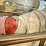 Josiah is registered to the contest to win money with this photo: newborn, baby, swaddled, hospital, blanket, hat, sleeping, bassinet, infant, face, person, bed, healthcare, rest, cute, toddler, child, soft, peaceful, newborncare