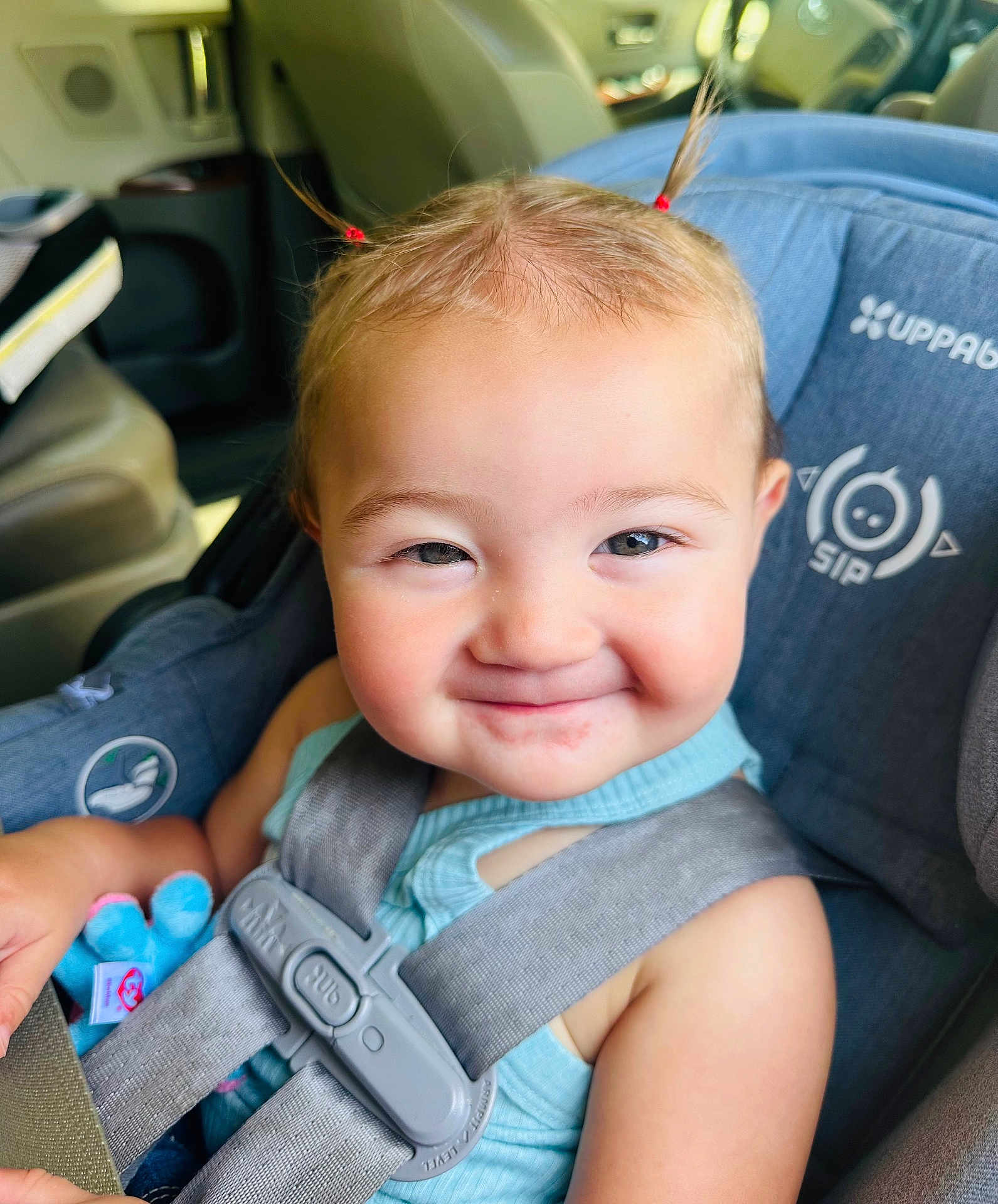 Briella is registered to the contest to win money with this photo: toddler, child, car_seat, smile, happy, baby, seatbelt, plush_toy, pigtails, blue_clothing, vehicle_interior, safety_harness, cute, portrait, infant, young_child, seat, head, person, baby_toy