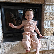 Capucine participe au concours pour gagner de l'argent avec cette photo : barefoot, casual, child, clothing, curly_hair, face, fireplace, floor, home, indoor, peach_outfit, person, portrait, reflection, sitting, stone, tiles, toddler, window, young_child