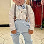 Gabriel a rejoint le concours — aidez-le/la à gagner de superbes lots ! blue_pants, bow_tie, boy, casual, child, clothing, face, floor, hair, hand, indoors, person, portrait, shoes, smiling, standing, suspenders, tile, toddler, white_shirt