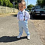Raphaël participe au concours pour gagner de l'argent avec cette photo : child, boy, street, sunny, outdoor, clothing, white_shirt, suspenders, light_blue_pants, sneakers, shadow, car, fence, tree, sidewalk, sky, portrait, standing, expression, daytime