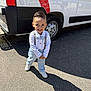 Raphaël a rejoint le concours — aidez-le/la à gagner de superbes lots ! child, boy, smiling, outdoor, pavement, white_shoes, light_blue_pants, white_shirt, bow_tie, suspenders, vehicle, van, tire, shadow, sunny, daylight, happy, standing, casual, portrait