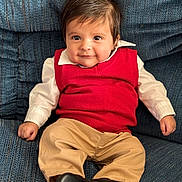 Liam joined the competition — help win amazing prizes! baby, infant, child, red_sweater, white_shirt, khaki_pants, black_shoes, blue_couch, upholstery, portrait, smile, dark_hair, big_eyes, sitting, indoors, cute, hands, feet, collar, fashion