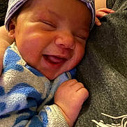 Zayden joined the competition — help win amazing prizes! apparel, baby, blue, closeup, clothing, cozy, cuddling, fabric, face, hand, happy, hat, infant, person, portrait, skin, sleeve, smiling, white, young_child