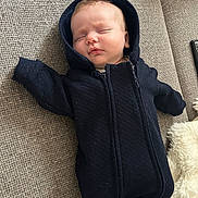 Nicolas a rejoint le concours — aidez-le/la à gagner de superbes lots ! baby, sleeping, hood, black_clothing, couch, blanket, cozy, infant, peaceful, indoors, child, soft, relaxation, portrait, resting, cute, young_child, fabric, texture, comfort