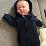 baby, sleeping, hood, black_clothing, couch, blanket, cozy, infant, peaceful, indoors, child, soft, relaxation, portrait, resting, cute, young_child, fabric, texture, comfort