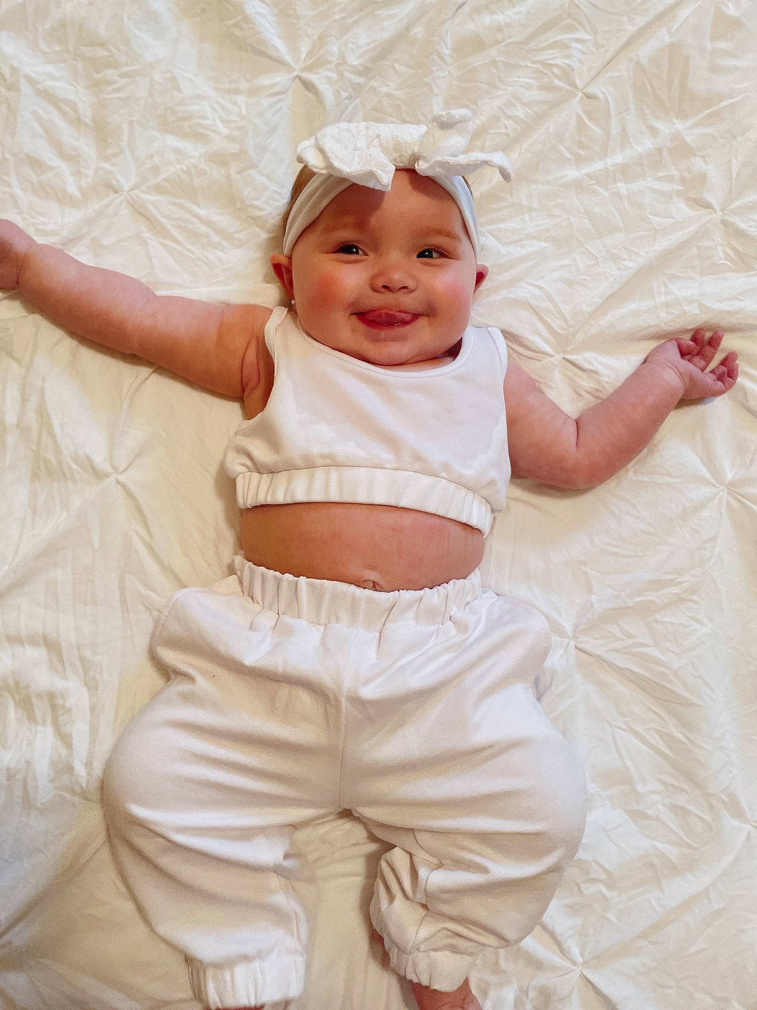 Leyla joined the competition — help win amazing prizes! baby, baby_toddler_clothing, child, comfort, face, facial_expression, gesture, happy, headwear, human_body, joy, linens, person, pink, product, skin, sleeve, smile, stomach, textile