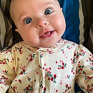 Kathryn joined the competition — help win amazing prizes! baby, infant, face, eyes, tongue, clothing, onesie, floral_pattern, blanket, striped, cute, portrait, child, smiling, happy, skin, young, person, indoors, closeup