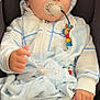 baby, blanket, blue_beanie, calm, car_seat, chubby_cheeks, close_up, cute, hand, hooded_outfit, infant, nursery_accessory, onesie, pacifier, pacifier_clip, portrait, sitting, sleepwear, soft_toy, toy