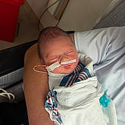 Dawson is registered to the contest to win money with this photo: newborn, baby, hospital, blanket, feeding_tube, pacifier, arm, person, sleeping, medical, patient, infant, wrapped, resting, closeup, indoor, care, tender, healthcare, human